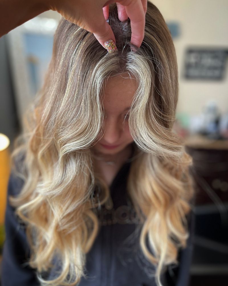 Long blonde hair finished with soft, bouncy blowout waves at JN Couture Salon Hayden Idaho